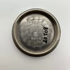 An image of the interior case back of a pre-owned Rolex women's wristwatch. The photograph is taken from a top-down angle, showing the inscriptions and serial numbers inside the circular metal case back. The surface displays engraved text and some hand-written numbers, with a slightly brushed texture. The image is captured at a close distance, highlighting the details of the inscriptions. The background is a plain, light surface.