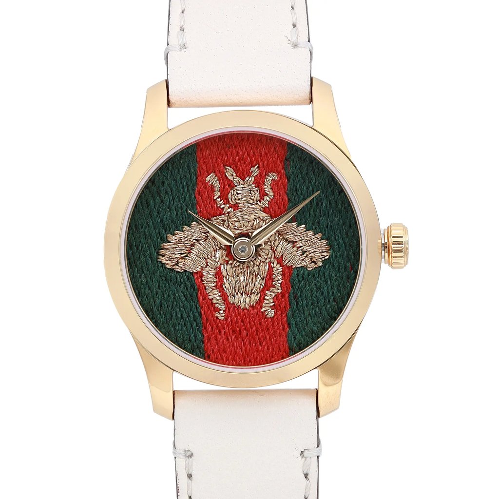 An image of a Wristwatch by Gucci. This Display Model item is designed for Women, featuring a Casual style. It has a Quartz movement and an Analog display with a Multicolor dial color. The indices include 12-Hour Dial,No Hour Marks. The band is made of Leather and the case is made of Stainless Steel. The watch has a Round shape with a case size of 27 mm and a case thickness of 8 mm.