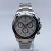 An image of a pre-owned men's Rolex Daytona Stainless Steel White Index Dial Automatic Men Watch 116520 positioned upright on a stand, captured from a frontal angle at a moderate distance. The watch features a chronograph with three subdials, luminous hands, and a small seconds subdial, set against a polished metal bracelet.