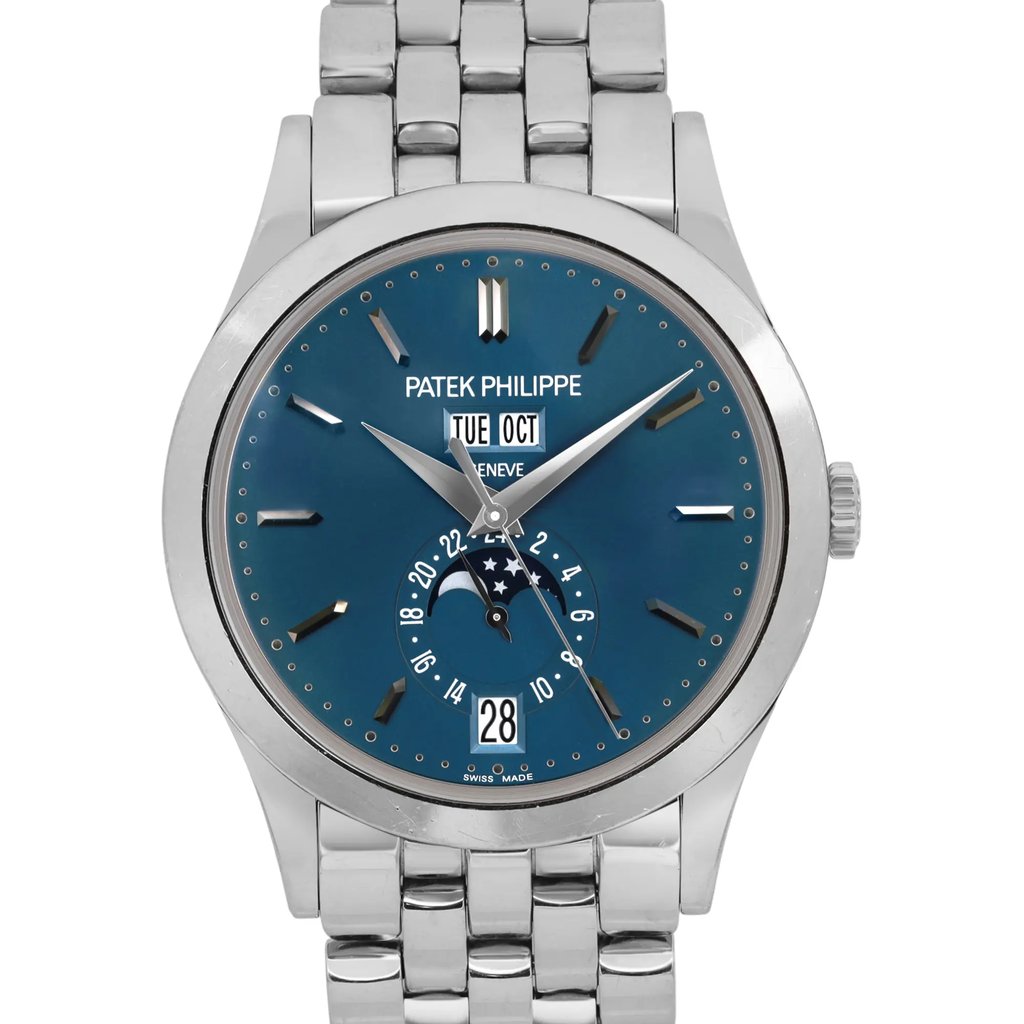 An image of a pre-owned men's Patek Philippe wristwatch, captured from a straight-on angle at a close distance. The watch features a blue dial with silver-tone hands and indices. It includes a date indicator and moon phase display. The white gold bracelet and polished case add to its elegant appearance.