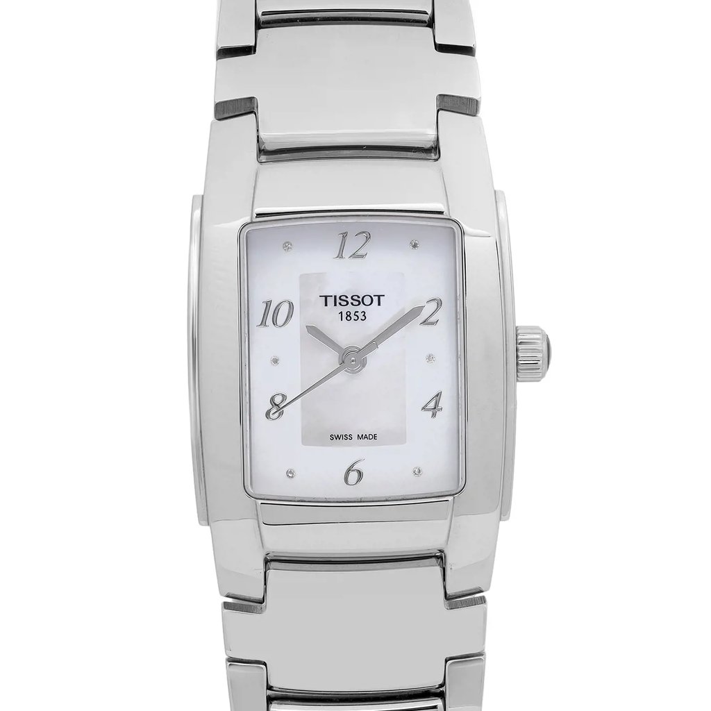 An up close image of a Tissot wristwatch, positioned front and center, facing directly towards the viewer. The watch features a rectangular silver case with a Mother Of Pearl dial, marked with black numerals at 12, 2, 4, 6, 8, and 10 o'clock positions. It has silver hands and a Tissot logo just below the 12 o'clock marker. Case and bracelet are stainless steel. Display model in excellent condition.
