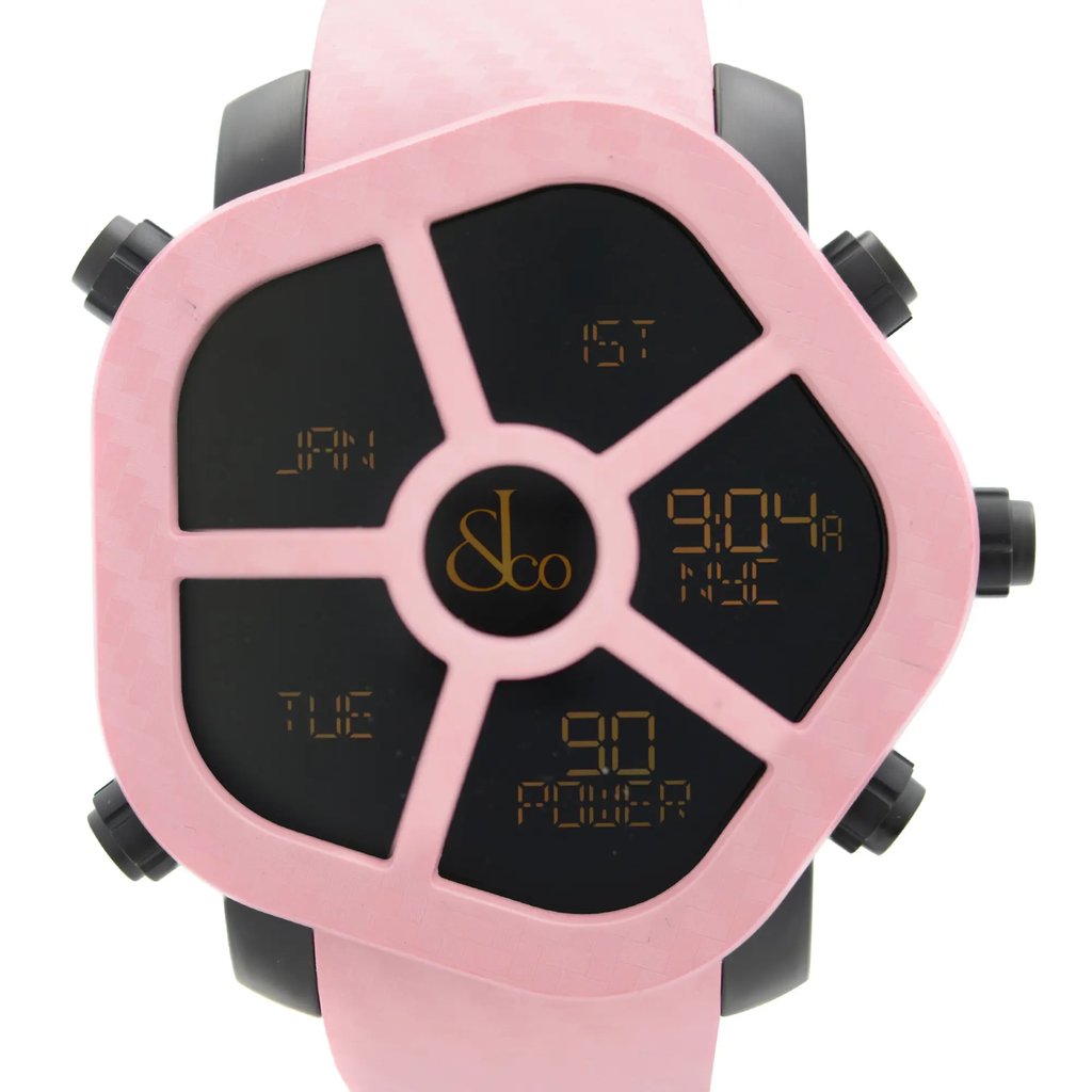 An image of a wristwatch taken from a front close-up angle, showcasing the watch face. The display model has a unique design with a pink frame and multiple digital displays in a segmented layout. The background is plain, highlighting the intricate details of the watch.
