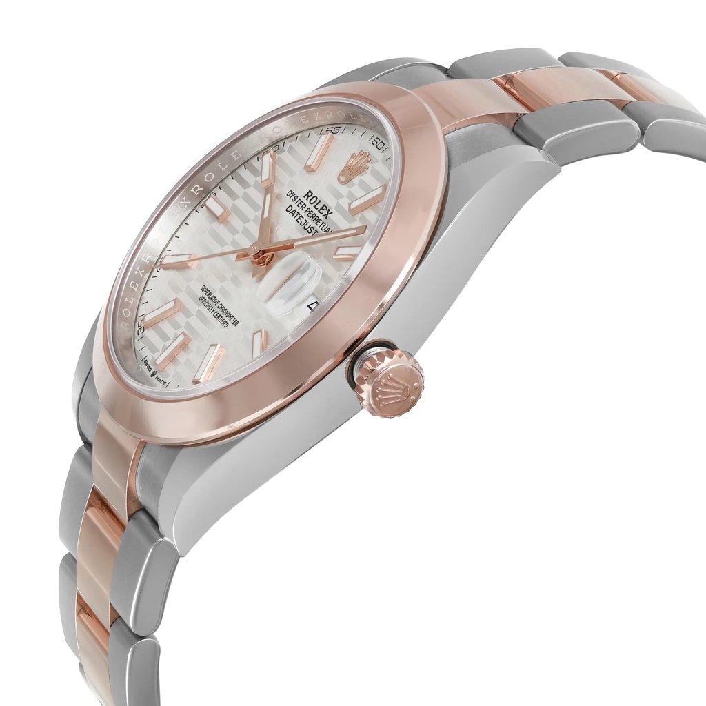 An image of an unworn Rolex men's wristwatch in a side profile view, focusing on the crown. The watch features a round stainless steel case with a rose gold bezel, and a silver sunburst dial with a date indicator and luminous hands. The band is made of alternating links of rose gold and stainless steel. The angle of the photo showcases the side of the watch, emphasizing the sleek design and the signature crown on the right side of the case. The distance is close enough to reveal the textures and colors but maintains the full view of the side profile.