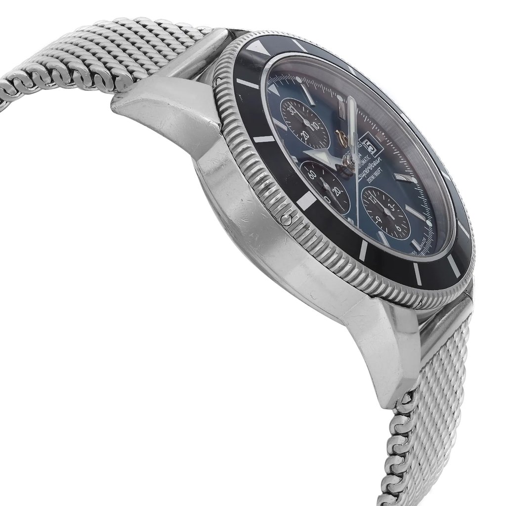 An image of a pre-owned Breitling men's wristwatch in a casual style, viewed from a side profile opposite the crown. The watch features a round stainless steel case and a stainless steel band with minor nicks visible on the case and case back. It has a black bezel with visible scratches on the bezel insert. The dial is blue with a sunburst pattern and is equipped with chronograph functions, a date indicator, and luminous hands, as well as a small seconds subdial. The watch is positioned at an angle that allows for a clear view of these features and the overall condition.