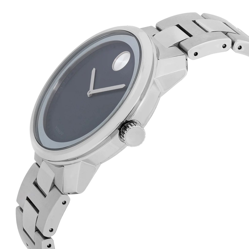 An image of a wristwatch in side profile view, showcasing the metallic crown prominently. The watch features a sleek, silver metallic band and a minimalist dark face with simple hour and minute hands. The position highlights the crown on the right side, and the angle captures the watch at a close distance, emphasizing its modern design and polished finish.