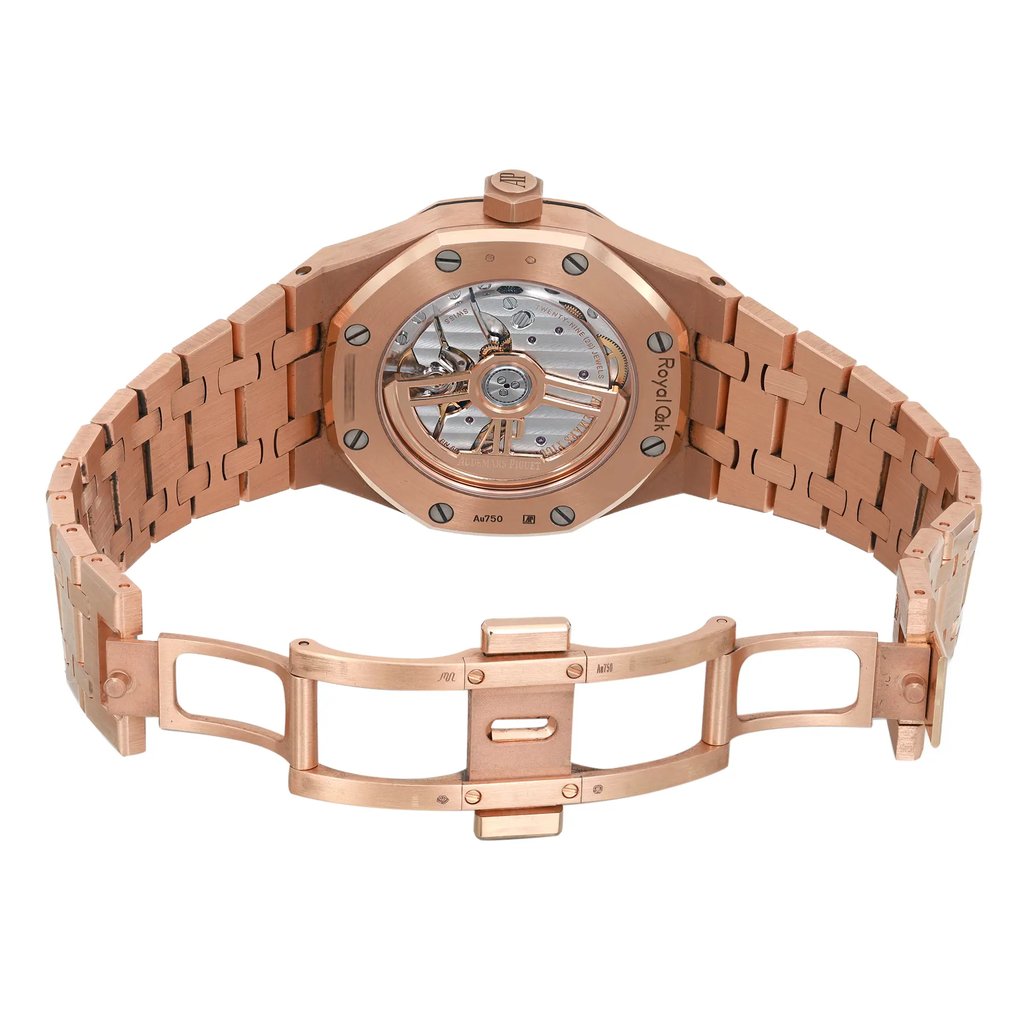 An image of a pre-owned men's Audemars Piguet wristwatch displayed from the back view with an open clasp. The watch features a rose gold octagonal case and band, with an exhibition caseback visible. The double-locking fold-over clasp is open, showcasing the intricate links of the band. The condition appears good, and the watch includes luminous hands. The angle is slightly elevated, offering a clear view of the watch’s back and clasp, with a medium distance to capture the details.