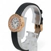 An image of a pre-owned Cartier women's wristwatch. The watch is positioned upright on a display stand, viewed from a slight side angle. The rose gold-toned case is adorned with diamonds around the bezel, and it features a white dial with Roman numeral hour markers. The black strap is visible, and the watch is shown at a close distance, highlighting its elegant details.