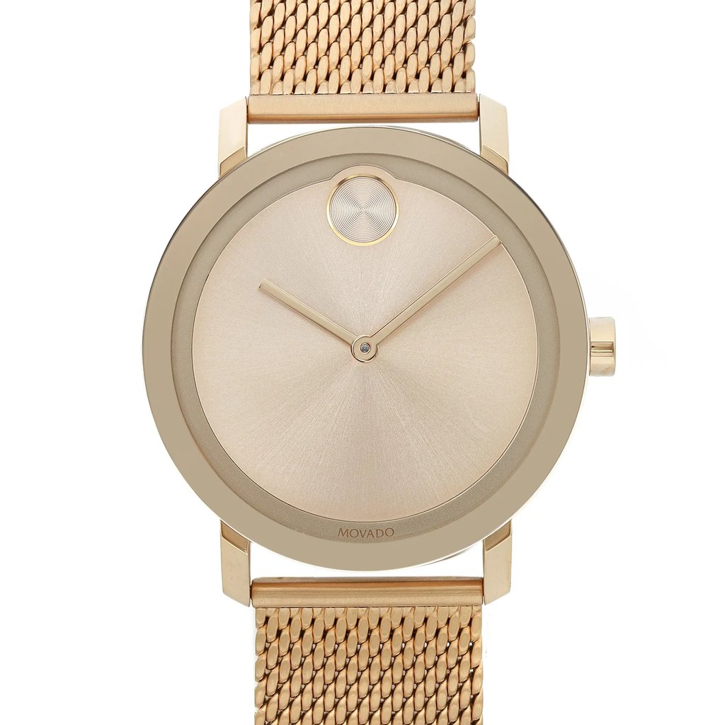 An image of a pre-owned wristwatch, captured from a front close-up angle. The focus is on the watch face, which features a minimalist design with a single dot at the 12 o'clock position, sleek hour and minute hands, and a smooth, metallic finish. The watch has a gold-toned mesh band visible at the top and bottom edges of the image.