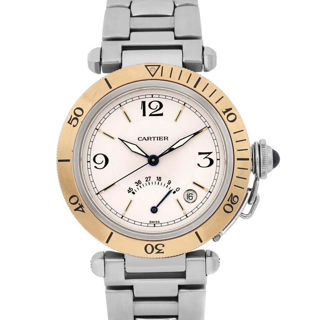 An image of a pre-owned Cartier men's wristwatch taken from a front-facing angle. The watch features a round face with a gold-toned bezel, displaying black numerals at the 12, 3, 6, and 9 o'clock positions. It includes a date indicator at the 4 o'clock position and luminous hands. The stainless steel bracelet is partially visible, and the watch crown is positioned on the right side. The photo captures the watch in close-up, emphasizing its elegant details and design features.