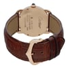 An image of a pre-owned wristwatch taken from the back view, showcasing the closed clasp. The focus is on the gold-toned case and detailed engravings. The watch features a brown leather strap with visible stitching, and the angle highlights the elegant curvature of the clasp. The photograph is taken at a close distance, capturing the watch's design and craftsmanship.