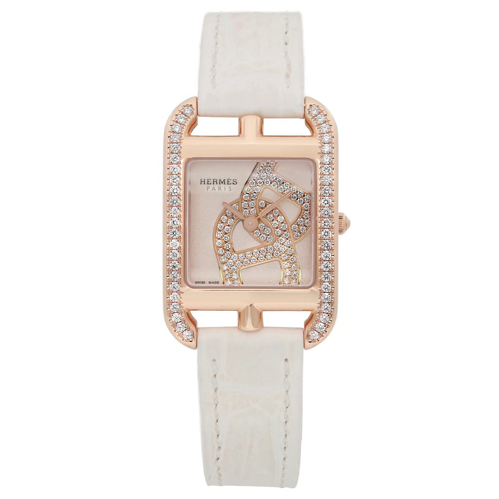 An image of a pre-owned HERMÈS Cod Joaillier women's wristwatch captured from a front-facing angle at close distance. The watch features a rectangular face with a 18k rose gold bezel adorned with diamonds. The cream dial showcases intricate diamond patterns, and the watch is paired with a white leather strap.