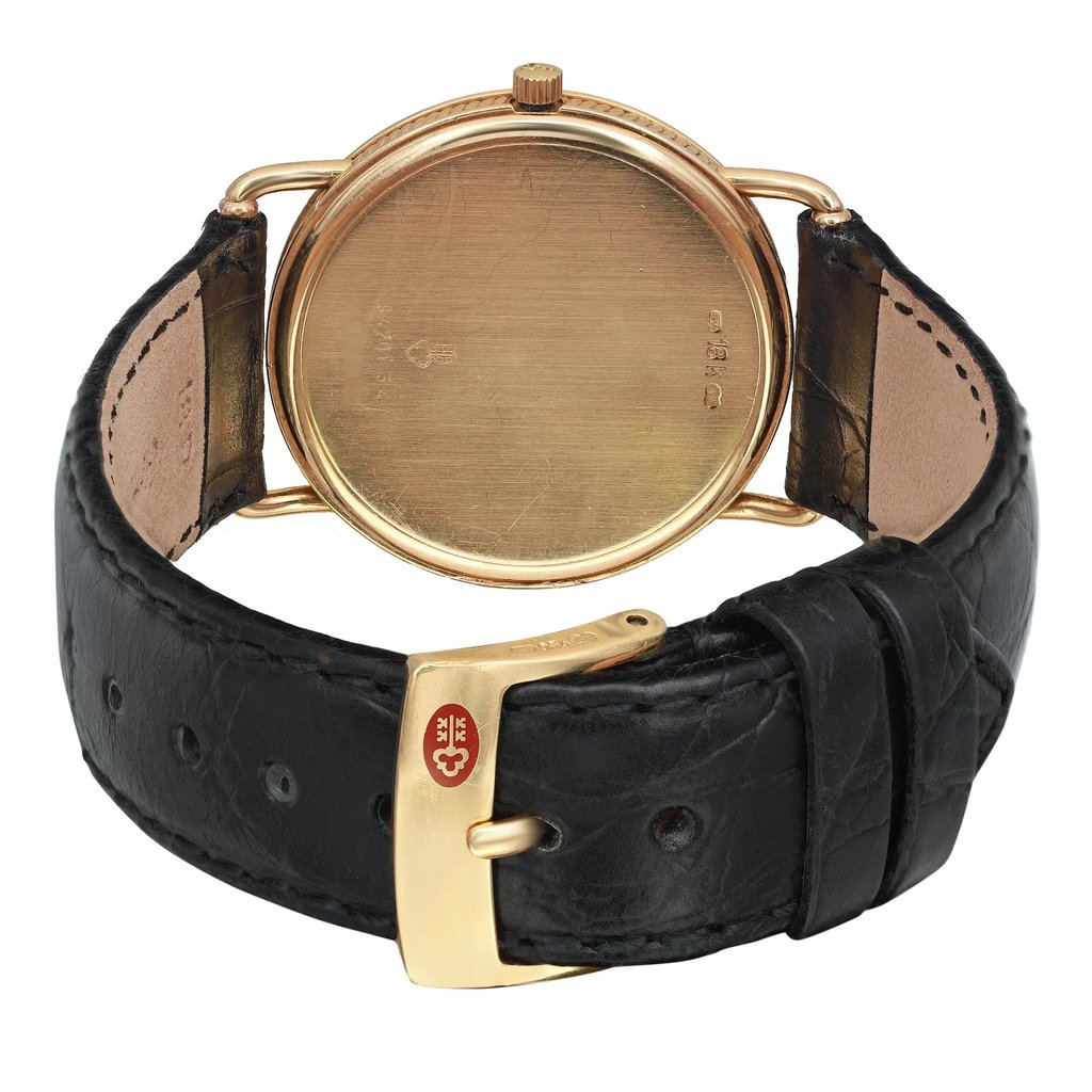 An image of a Wristwatch by Corum. This Pre Owned item is designed for Unisex Adult, featuring a Classic style. It has a Quartz movement and an Analog display with a White dial color. The indices include 12-Hour Dial,Arabic Numerals. The band is made of Leather and the case is made of Yellow Gold. The watch has a Round shape with a case size of 32 mm and a case thickness of 5 mm.