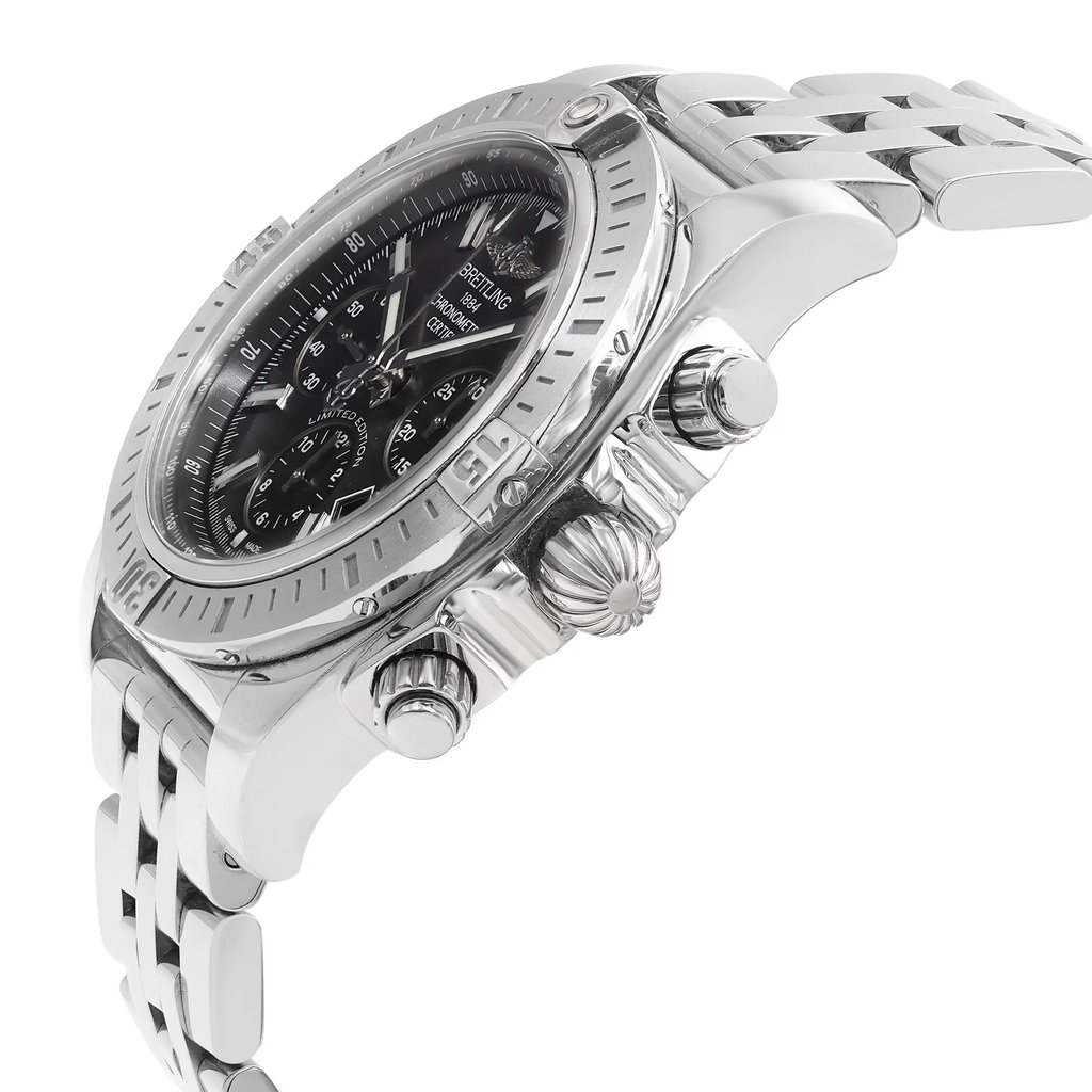 An image of a pre-owned Breitling men's wristwatch in a luxury style, presented in a side profile view highlighting the crown. The watch has a round stainless steel case with a sunburst gray dial, steel bezel, and stainless steel band. It is positioned at a slight angle with the watch face visible and the crown and pushers prominently displayed. The image is taken from a close distance, showcasing the watch's details. The watch is pre-owned and may have minor scratches and signs of wear.