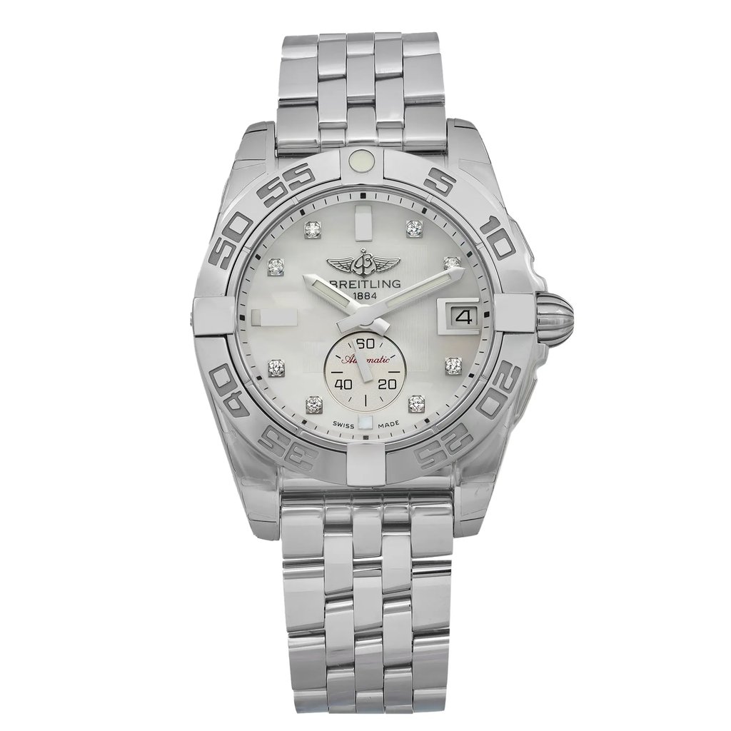 An image of an unworn Breitling women's luxury wristwatch, presented in a full frontal view. The watch features a round stainless steel case with a gray bezel and a white mother of pearl dial. The dial showcases diamond markers and luminous hands, a date indicator at the 3 o'clock position, and the Breitling logo. It has a 12-hour dial display and is attached to a stainless steel band. The original protective sticker is visible on the case, indicating its excellent condition.