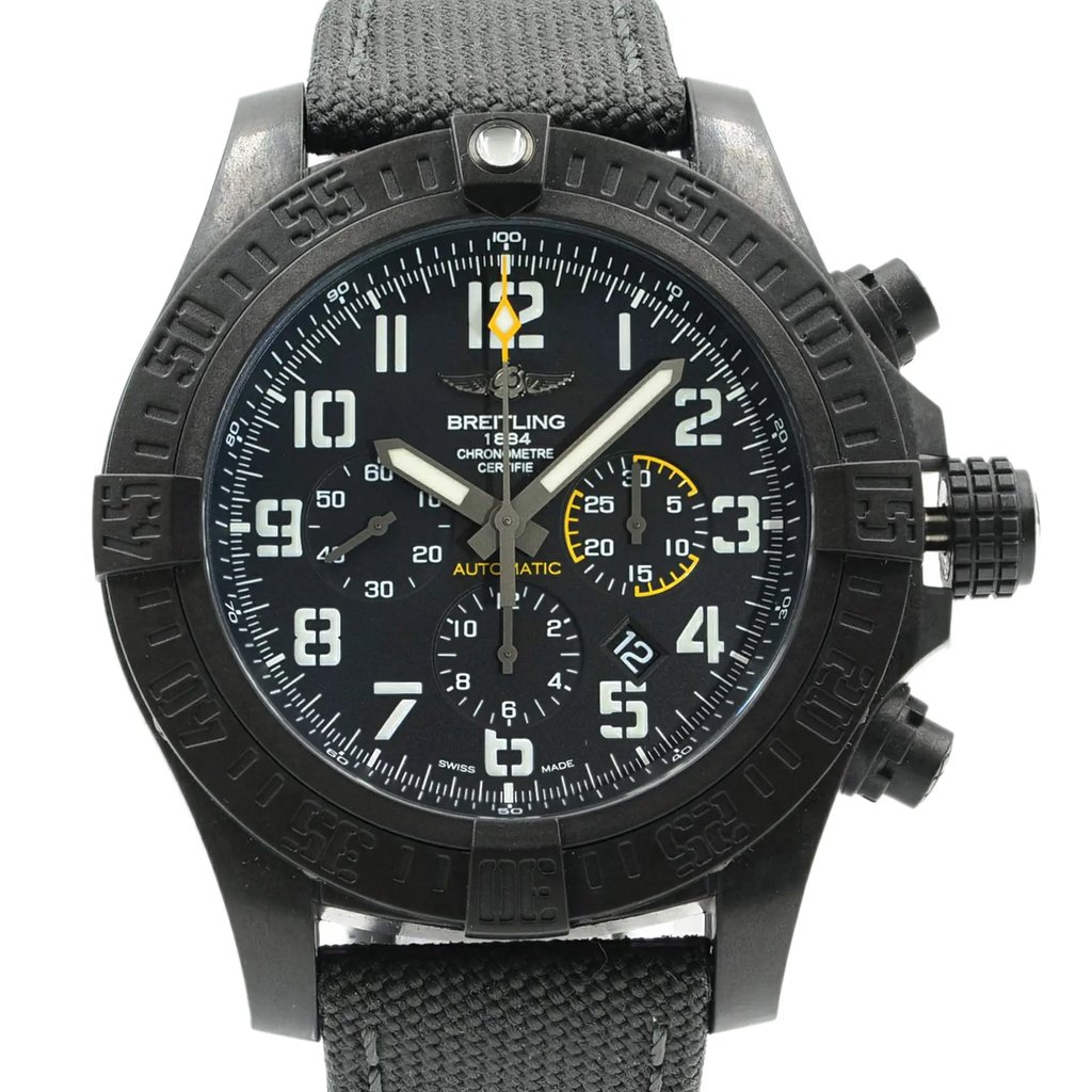 An image of a wristwatch taken from the front at a close-up angle, showcasing the detailed watch face. The watch is a display model, featuring a black bezel and textured strap. The dial includes large, clear numerals and subdials, with contrasting yellow accents. The brand name is visible on the watch face.
