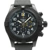 An image of a wristwatch taken from the front at a close-up angle, showcasing the detailed watch face. The watch is a display model, featuring a black bezel and textured strap. The dial includes large, clear numerals and subdials, with contrasting yellow accents. The brand name is visible on the watch face.