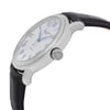 An image of a Raymond Weil men's wristwatch in excellent condition, displayed from a side profile view. The focus is on the stainless steel crown, featuring the brand's logo. The watch has a round shape with a steel bezel, a silver tapisserie-patterned dial, and a date indicator. The band is made of black leather, contributing to its formal dress style. The angle highlights the crown and part of the dial, showing the elegant design details.