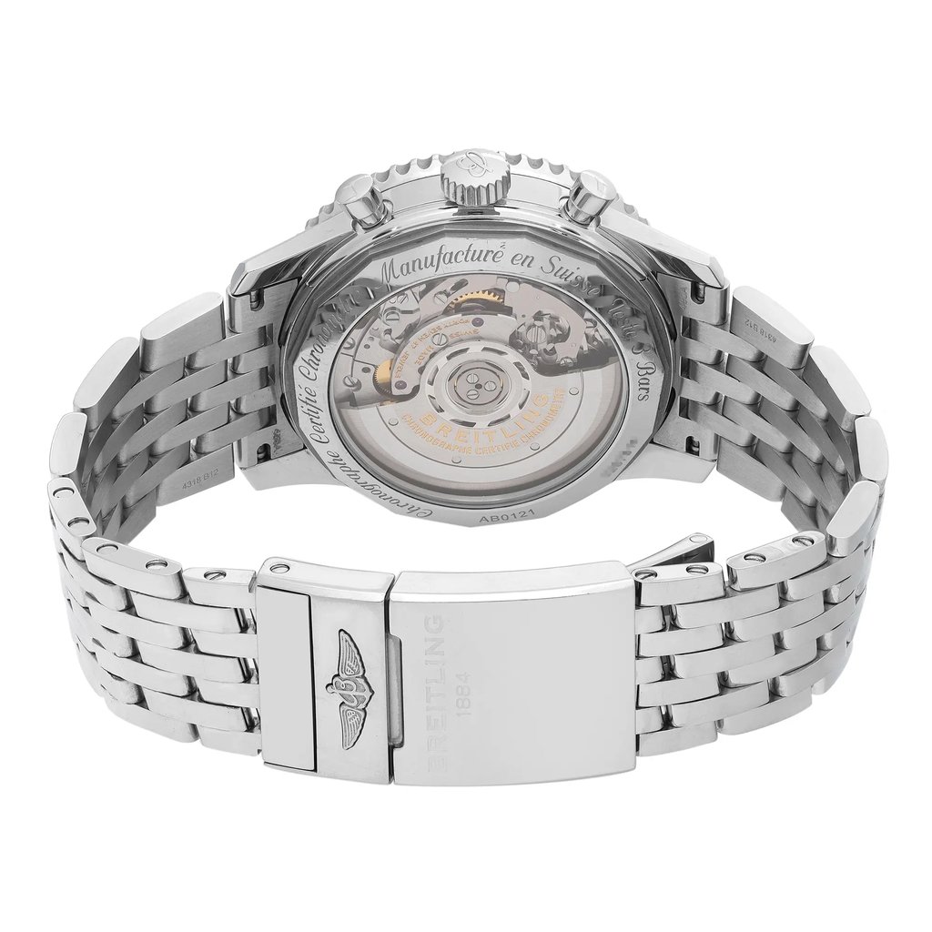 An image of a pre-owned Breitling men's wristwatch viewed from the back, showing an exhibition caseback and stainless steel fold-over clasp with flip lock safety in a closed position. The watch is photographed head-on with the caseback and clasp in clear focus, demonstrating intricate mechanical details and branding, while the stainless steel band extends to either side of the frame. The round watch case is centered in the image with a slight angle that allows visibility of the side profile, emphasizing the depth and contours of the design. The watch is pre-owned and shows light signs of wear and scratches. 