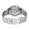 An image of a pre-owned Breitling men's wristwatch viewed from the back, showing an exhibition caseback and stainless steel fold-over clasp with flip lock safety in a closed position. The watch is photographed head-on with the caseback and clasp in clear focus, demonstrating intricate mechanical details and branding, while the stainless steel band extends to either side of the frame. The round watch case is centered in the image with a slight angle that allows visibility of the side profile, emphasizing the depth and contours of the design. The watch is pre-owned and shows light signs of wear and scratches. 