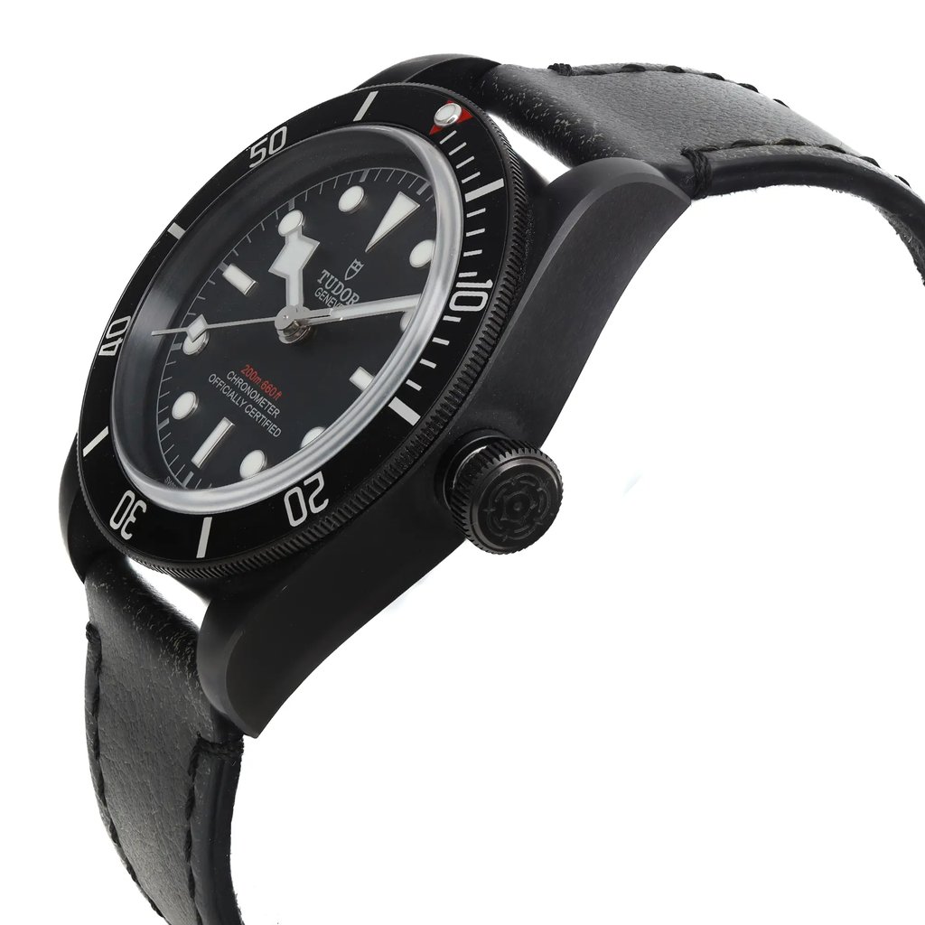 An image of a display model wristwatch captured from a side profile view, showcasing the crown prominently. The watch features a black bezel with white numerals and a black dial with luminous markers. The angle highlights the thickness and design of the watch case, along with a textured black leather strap. The watch appears to be positioned at a medium distance, allowing for clear visibility of the details.