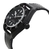 An image of a display model wristwatch captured from a side profile view, showcasing the crown prominently. The watch features a black bezel with white numerals and a black dial with luminous markers. The angle highlights the thickness and design of the watch case, along with a textured black leather strap. The watch appears to be positioned at a medium distance, allowing for clear visibility of the details.