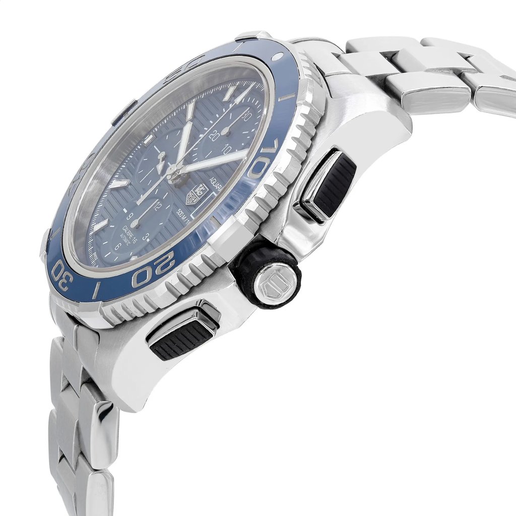 An image of a pre-owned TAG Heuer men's diver wristwatch, shown from a side profile view. The watch features a round shape with a blue dial and blue bezel. The stainless steel case and band are prominently displayed, with the crown clearly visible. The watch includes chronograph functionality, a date indicator, and luminous hands. The angle highlights the sleek design and craftsmanship of the stainless steel bracelet.