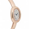 An image of a pre-owned Cartier women's wristwatch. The watch is positioned at a slight angle, showcasing its elegant oval face with Roman numerals on a silver dial. The case and bangle-style bracelet are made of a polished rose gold metal with the shot taken from a close distance to highlight the details. The hands of the watch are blue, adding a subtle contrast to the overall design.