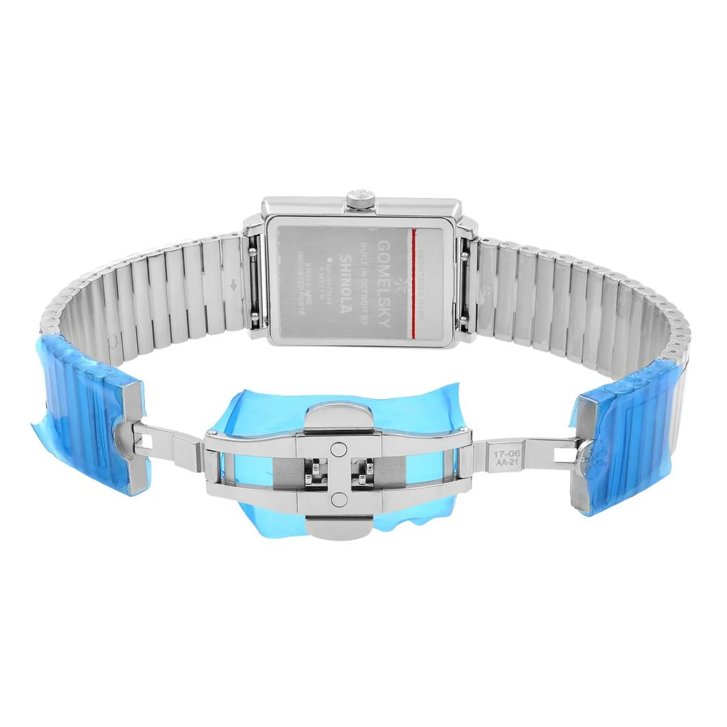 An image of a wristwatch taken from the back view, showcasing the open clasp. The watch has a rectangular case and a metal link band. The clasp is fully extended in the center of the image, with protective blue plastic covering parts of the band. The watch is shown in an unworn condition, captured at a close distance and straight angle to highlight the details of the back and clasp mechanism.