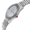 An image of a new, unworn Rado women's wristwatch in a dress/formal style, captured in a side profile view where the crown is visible. The watch features a round stainless steel case and a stainless steel band. It has a white mother of pearl dial with stainless steel bezel, and the Rado logo is clearly seen on the dial. The image is taken from a mid-range distance, focusing on a roughly 45-degree angle to the watch face to emphasize the side profile and the crown detail.