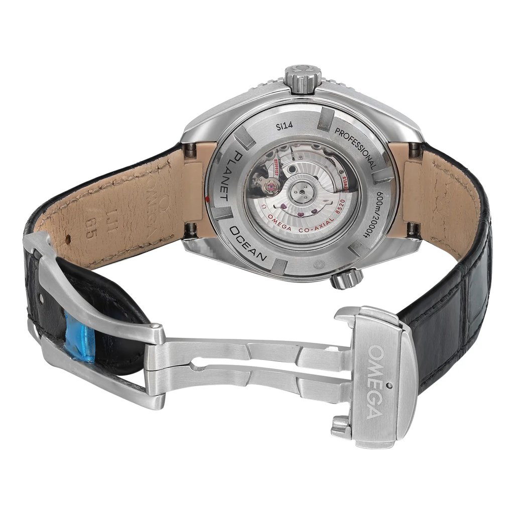 An image of a pre-owned wristwatch shown from the back view with an open clasp. The watch is positioned to display the intricate details of the movement through a transparent case back. The angle captures the watch slightly from above, providing a clear view of the leather strap and the metal clasp engraved with "OMEGA." The photo is taken at a moderate distance, focusing on the craftsmanship of the watch's back.