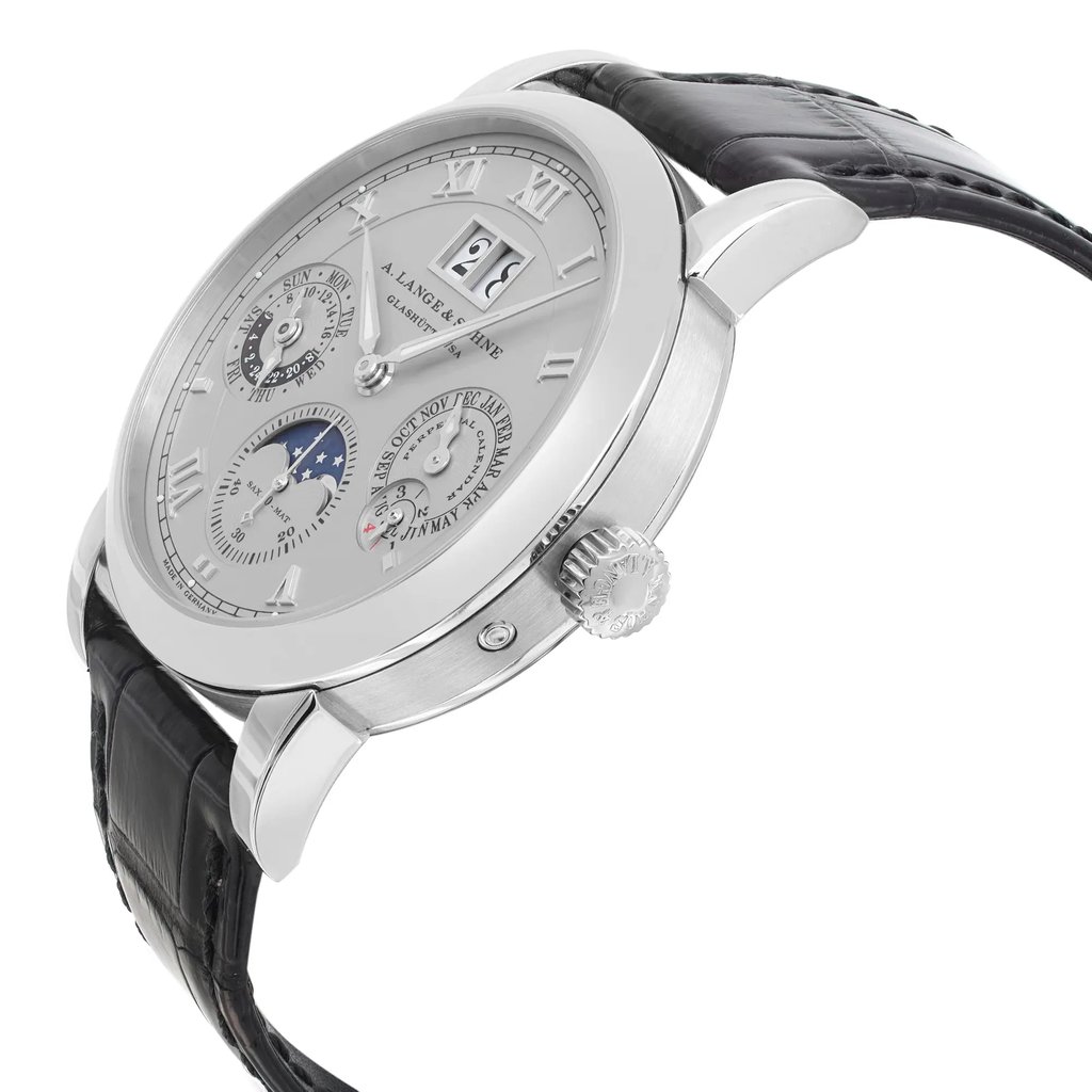 An image of a pre-owned wristwatch captured from a side profile view. The watch is positioned at a slight angle, showcasing the crown prominently. The case appears metallic with a polished finish, and the watch face includes multiple sub-dials and Roman numeral hour markers. The black leather strap is partially visible, enhancing the elegant design. The photo is taken at a close distance, highlighting the intricate details of the watch.