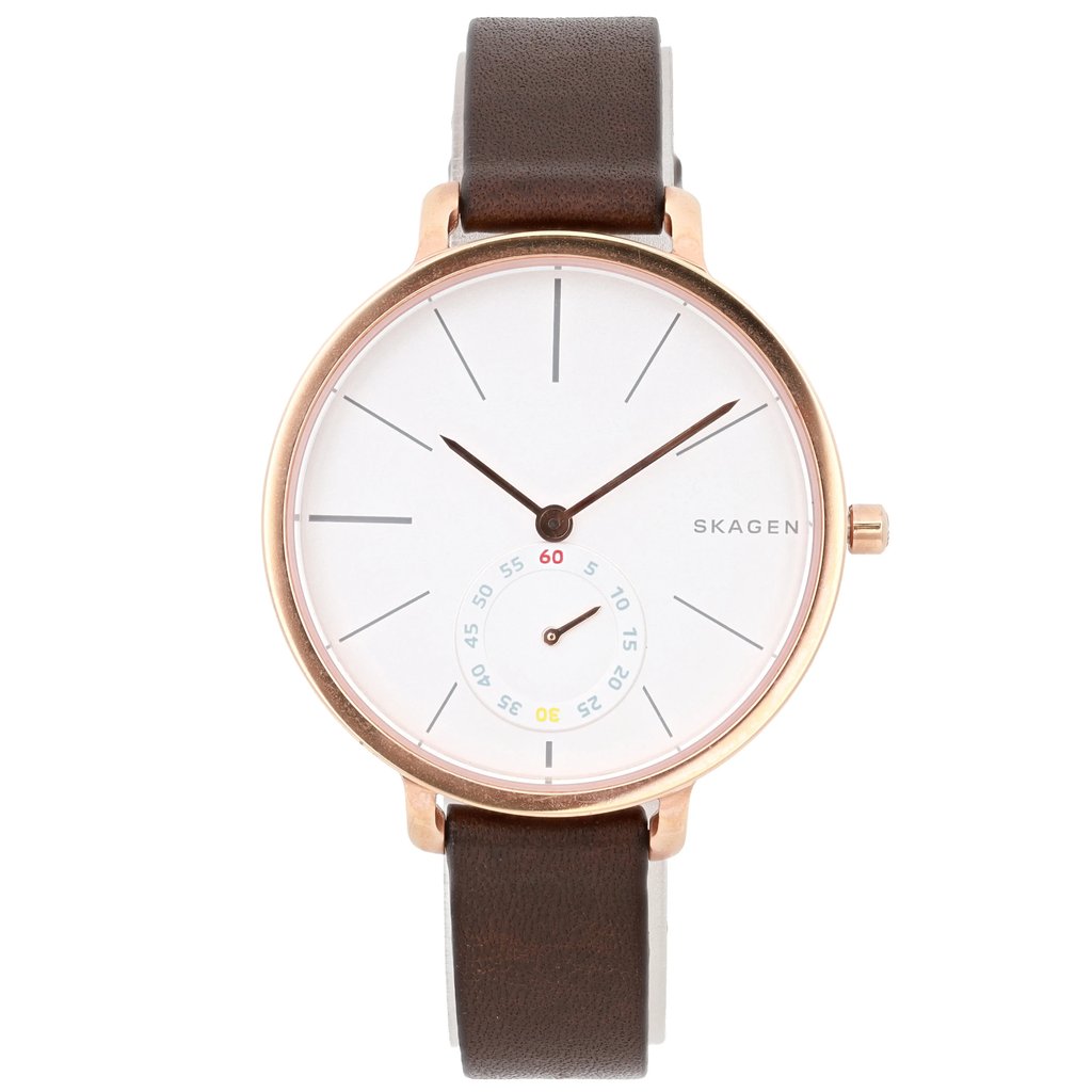 An image of a pre-owned Skagen wristwatch taken from a front-facing angle. The watch features a minimalist design with a white dial and slim black hour markers. It includes a small subdial with colorful numerals. The case has a rose-gold tone, and the watch is paired with a dark brown leather strap. The entire watch is centered in the image, captured at a close distance.