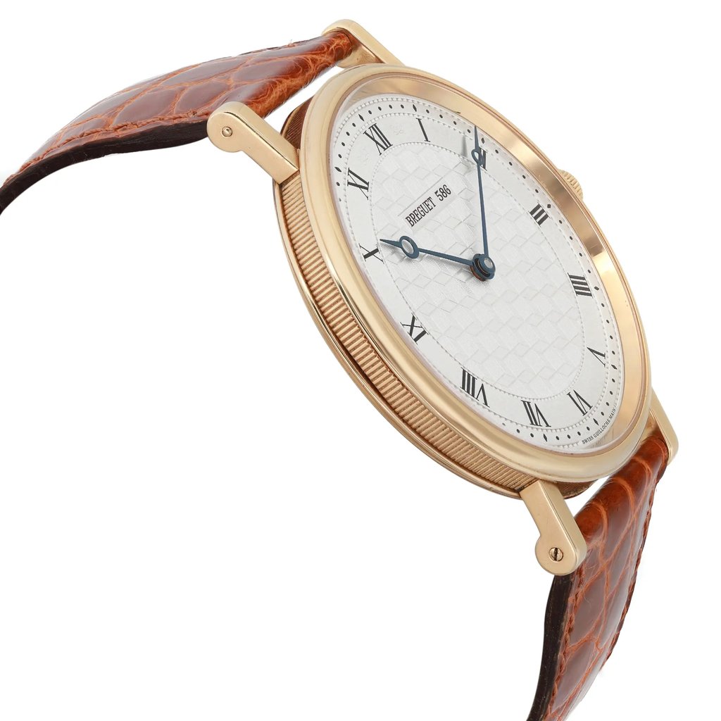 An image of a pre-owned Breguet men's luxury wristwatch, displayed in a side profile view opposite of the crown. The watch features a round 18k yellow gold case with minor signs of wear, a silver geometric pattern dial, and a gold bezel. It is fitted with a brown leather band and the photo is taken from a close distance, capturing the watch at an angle to emphasize its profile and the curvature of the case.