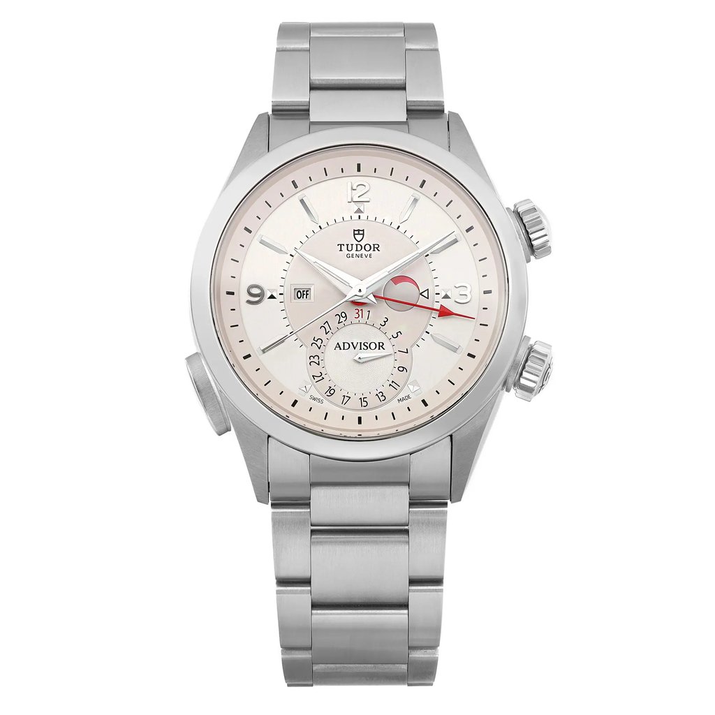 An image of a TUDOR  Heritage Advisor 42mm men's wristwatch in unworn condition, featuring a stainless steel bracelet and a round silver dial with a date indicator and luminous hands. The watch is positioned upright, viewed from the front at a slight downward angle, and captured at a close distance to highlight its details. The face of the watch displays a combination of silver and white tones with a prominent red hand.