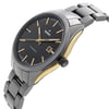 An image of a pre-owned wristwatch shown from a side profile view. The watch features a visible crown on the right side. It has a black dial with gold hour markers and hands, and a date window at the 3 o'clock position. The case is highlighted with gold accents, and the metal bracelet is visible, angled slightly upwards. The photograph is taken from a close angle, emphasizing the watch's sleek design.