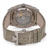 An image of a pre-owned men's Vacheron Constantin wristwatch. The watch is positioned with its back facing the viewer, showcasing the intricate mechanical movement through a transparent case back. The angle is slightly elevated and close-up, highlighting the detailed design of the movement and the engraved brand name around the edge. The leather strap is visible, clasped with a distinctive metal buckle, and presented in a neutral tone.