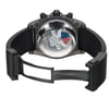 An image of a pre-owned Breitling men's wristwatch with a round stainless steel case and solid caseback featuring an "American Tour" engraving. The watch is presented from a rear view, showcasing its open fold-over clasp with double push-button on a black rubber band. The watch is angled to display the clasp mechanism partially extended on the right side, and it is photographed at a close distance, ensuring clear visibility of the details on the caseback. The watch is pre-owned and may show light signs of wear and scratches. 
