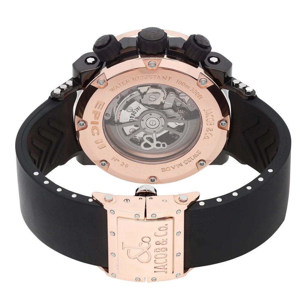 An image of a pre-owned wristwatch, viewed from the back to showcase the closed clasp and intricate internal mechanisms. The watch features a prominent rose gold-toned back casing with visible gears through a transparent section. The black strap is partially visible, adorned with small metallic accents. The brand name "Jacob & Co." is engraved on the clasp. The angle is slightly elevated, capturing the watch's details up close.