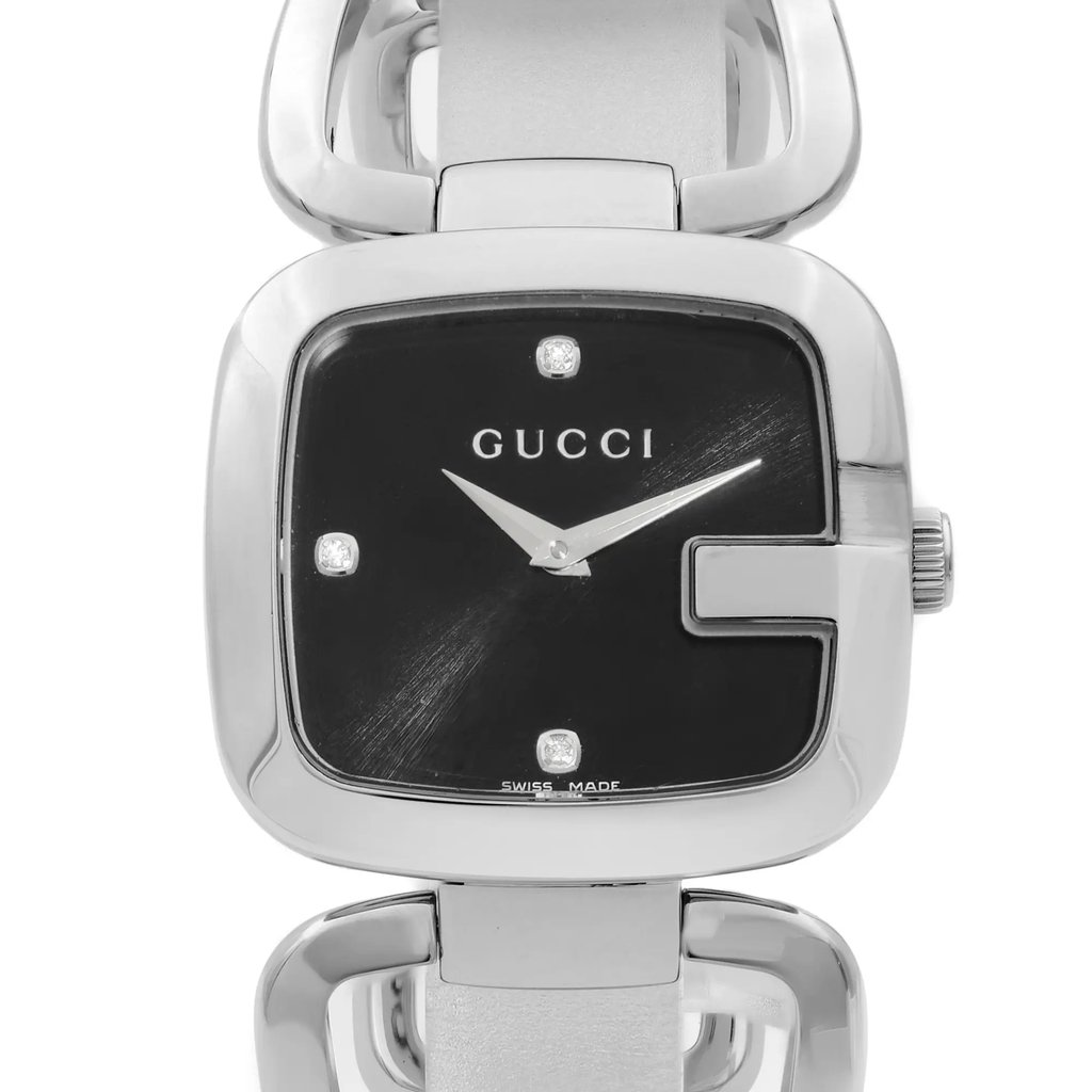 An image of a pre-owned Gucci women's wristwatch in good condition, presented in a front close-up shot. The watch face is round with a black sunburst pattern dial, accentuated by silver diamond markers and non-numeric hour marks. A silver stainless steel bezel surrounds the dial, and the band is also made of stainless steel. The Gucci logo is prominently displayed at the center top of the dial. The watch is positioned straight-on to the camera, allowing a clear view of the details, and the image is taken from a close distance, focusing on the watch face and the upper part of the band.