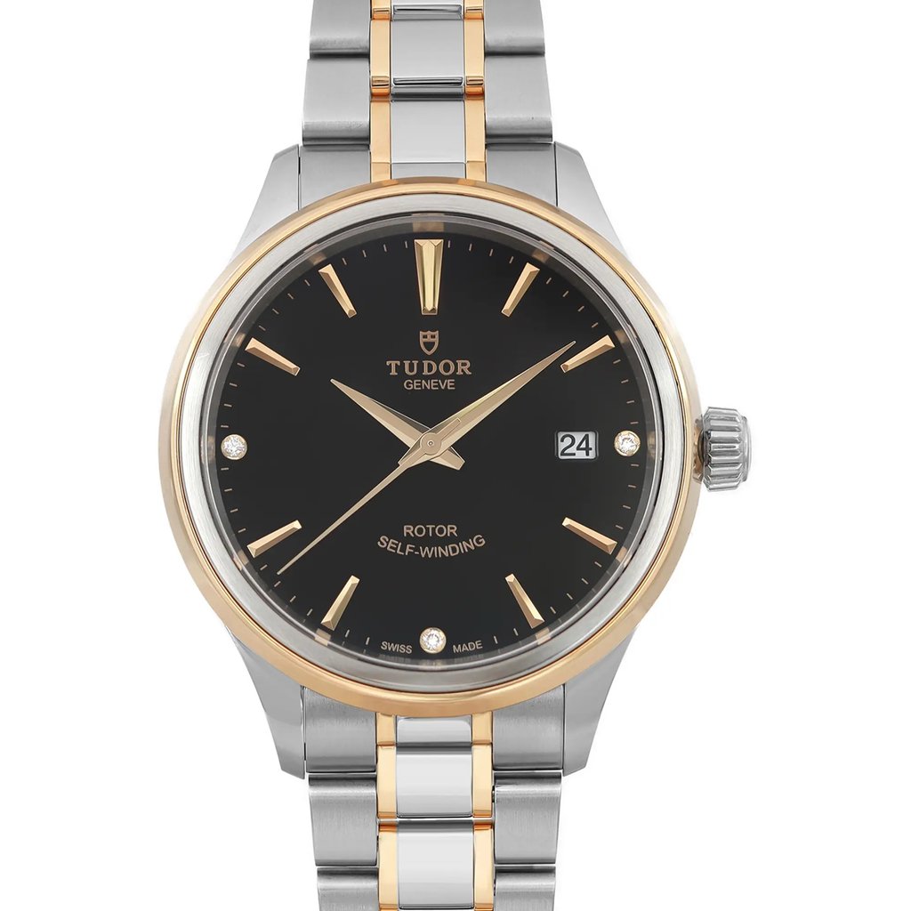 An image of a wristwatch taken from a front close-up angle, showcasing the watch face. The watch is unworn, featuring a black dial with gold hour markers and hands. The bracelet is a combination of silver and gold tones. The date is visible on the right side of the watch face.