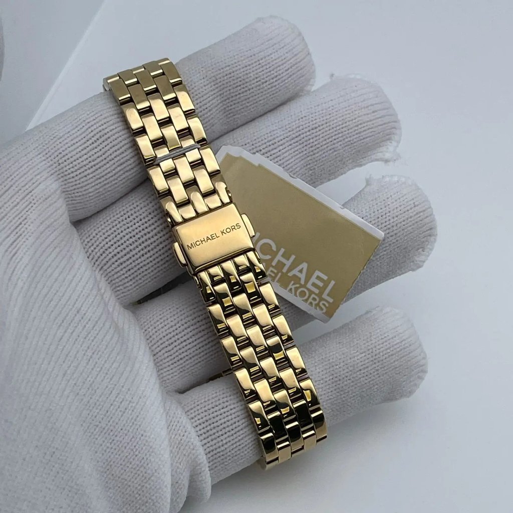 An image of a Wristwatch by Michael Kors. This Pre Owned item is designed for Women, featuring a Dress/Formal style. It has a Quartz movement and an Analog display with a Champagne dial color. The indices include 12-Hour Dial,Non-Numeric Hour Marks. The band is made of Stainless Steel and the case is made of Stainless Steel. The watch has a Round shape with a case size of 33 mm and a case thickness of 8 mm.