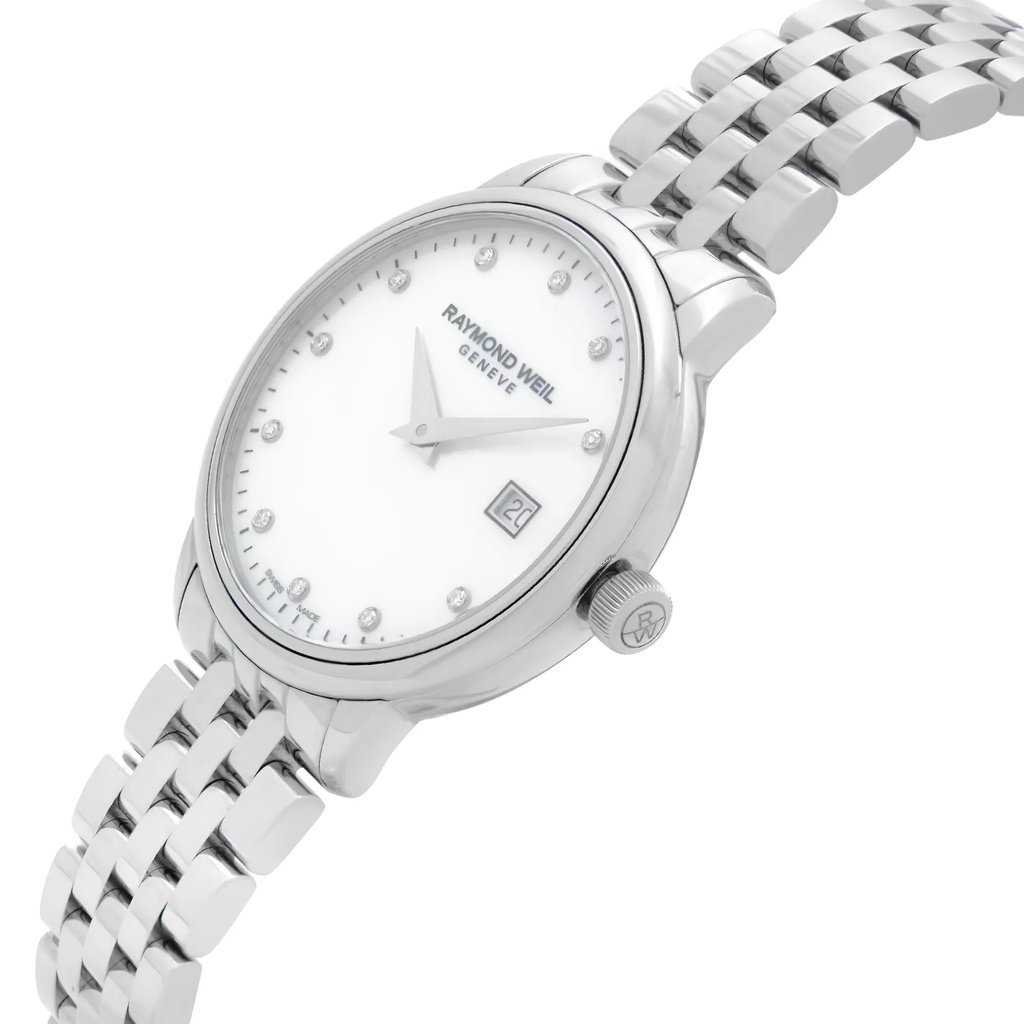 An image of an unworn RAYMOND WEIL women's wristwatch in a dress/formal style. It presents a side profile view with the crown visible, positioned at a slight angle to show off the stainless steel band and case. The watch has a round shape with a white mother of pearl dial featuring diamond hour markers and the RAYMOND WEIL logo. A date window is visible at the 3 o'clock position. The image is taken from a close distance, emphasizing the details and design of the watch.