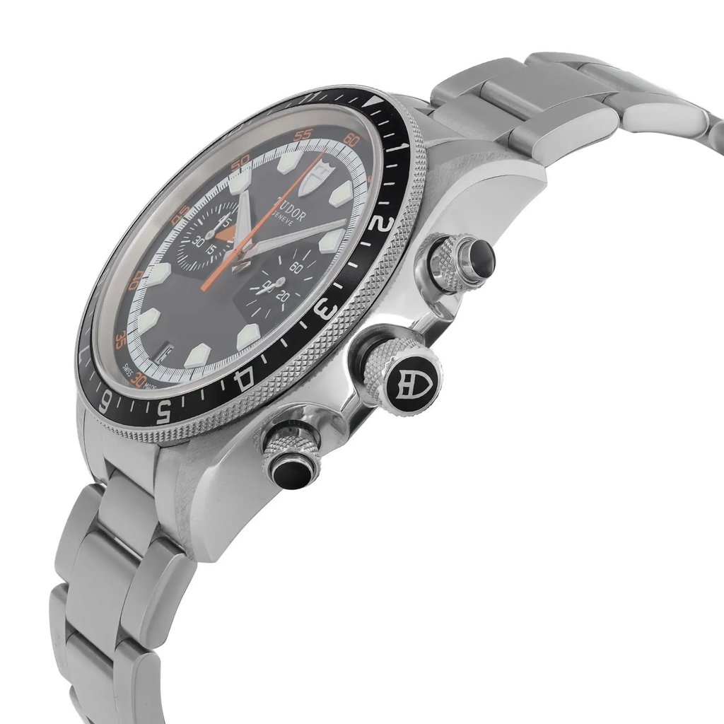 An image of a wristwatch in a side profile view, showcasing the crown and chrono pushers. The watch has a metallic bracelet and a detailed bezel with engraved numerals. The face of the watch includes prominent hour markers and subdials. The angle highlights the watch's thickness and design features, taken at a close distance to emphasize its craftsmanship.