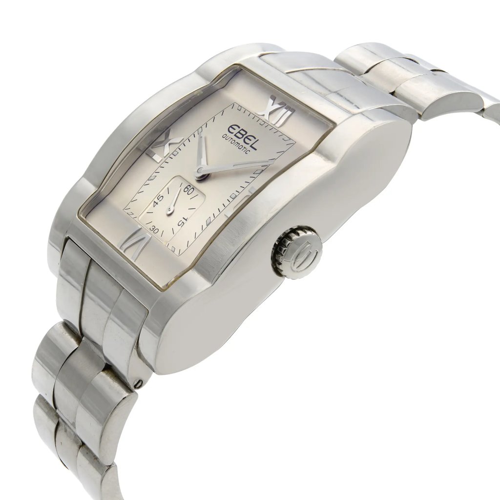 An image of a pre-owned wristwatch shown from a side profile view, with a focus on the crown. The watch features a rectangular silver case and a matching metallic band. The face displays Roman numerals and a smaller subdial, captured at a slight angle to highlight its design and details.