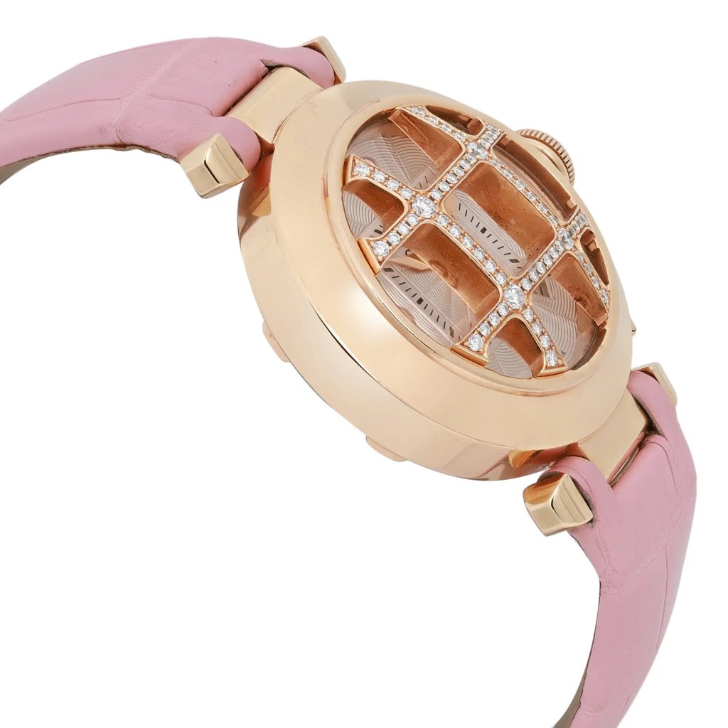 An image of a pre-owned Cartier women's wristwatch taken from a side angle, showcasing its elegant rose gold case and intricate face design. The watch features a pink leather strap attached to the case with gold connectors. The face includes a date indicator, and a grid-like design with sparkling embellishments is visible under the crystal. The watch is positioned at a slight angle, highlighting its luxurious details and craftsmanship.