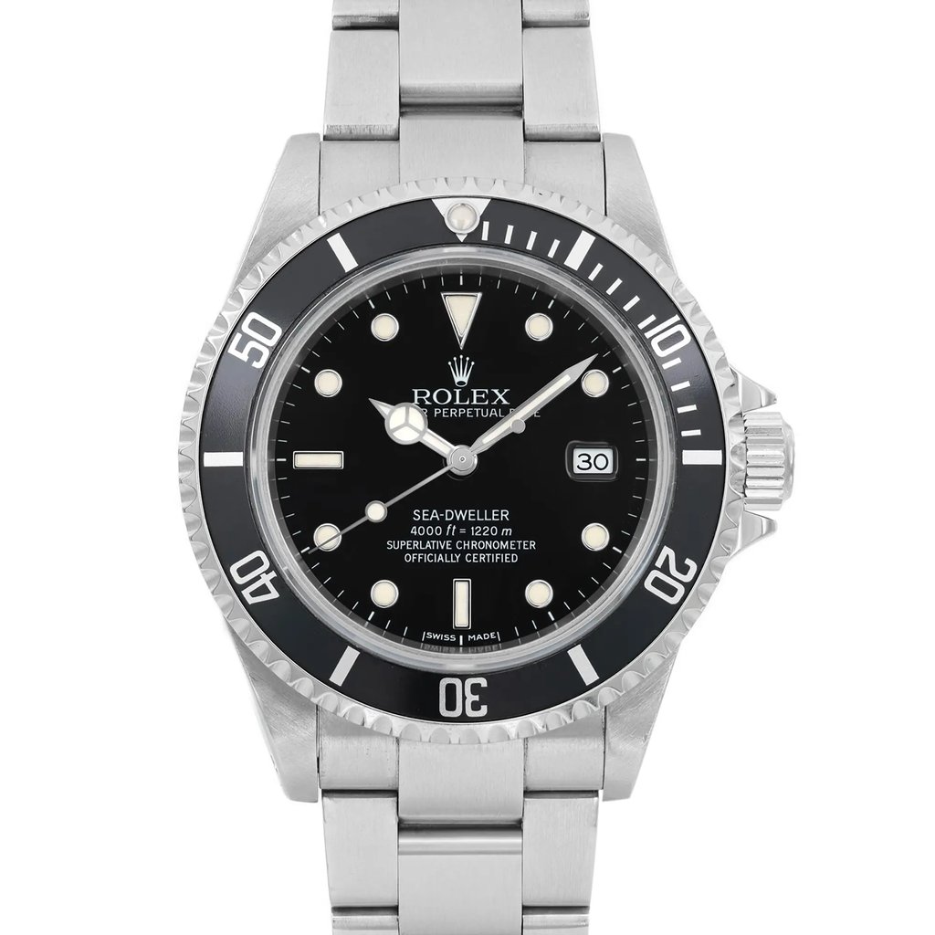 An image of a pre-owned men's luxury Rolex wristwatch. The shot is a front close-up of the watch face, highlighting its round black dial with round indices and a black bezel. The stainless steel band and case are visible, showcasing the watch's high-quality construction. Features include a date indicator and luminous hands. The watch is in good condition.