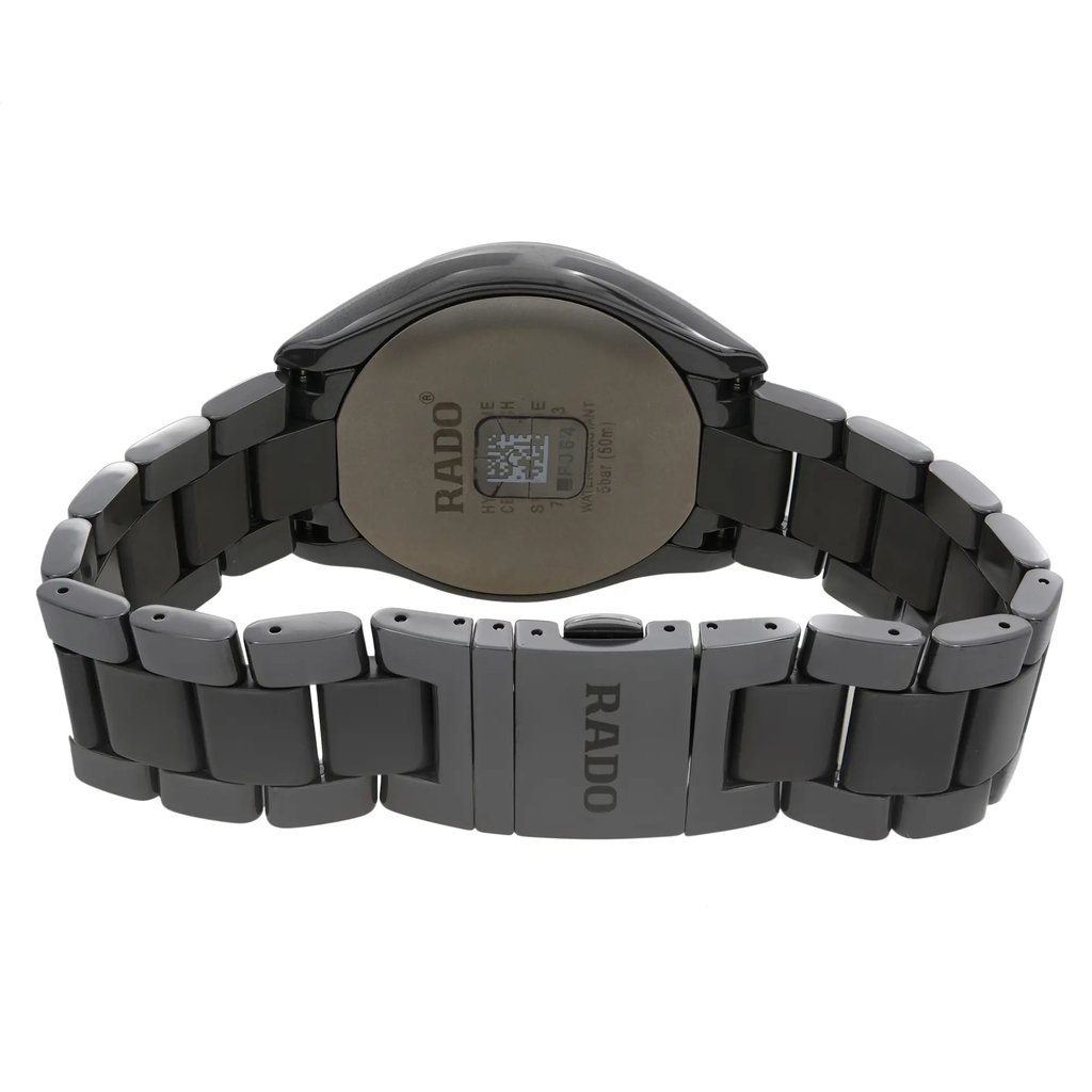 An image of a wristwatch displayed from the back view, showing the closed clasp. The watch is a display model and features a metallic finish with a smooth, reflective surface. The brand name "RADO" is visible on the clasp. The angle captures the watch face down, highlighting the details on the back of the watch case and bracelet links. The close-up shot provides a clear view of the craftsmanship and design elements.