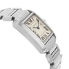 An image of a pre-owned Cartier women's wristwatch, captured from a side angle. The watch features a rectangular face with Roman numeral hour markers and a date indicator. The stainless steel metal bracelet is partially visible, and the watch is positioned at a slight tilt, showcasing its elegant design. The close-up shot highlights the watch's details and craftsmanship.