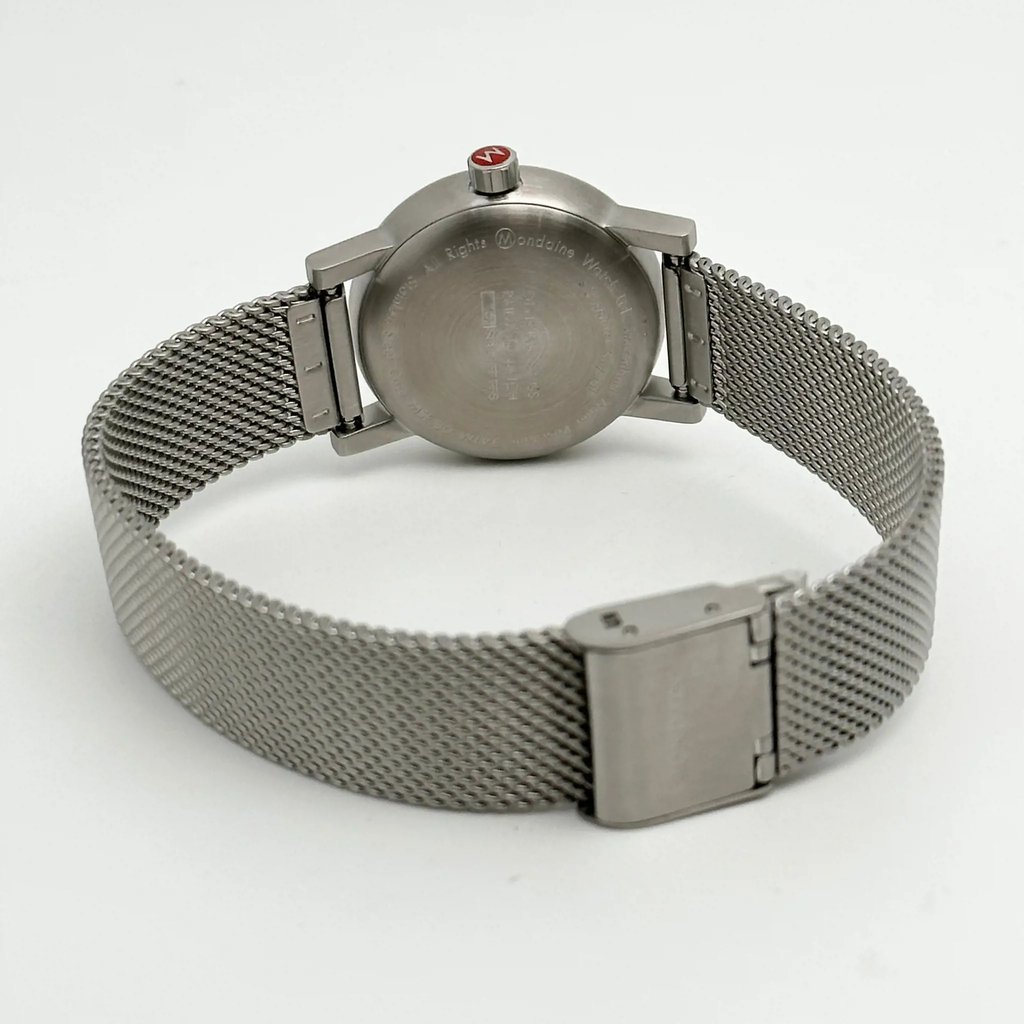 An image of a Wristwatch by Mondaine. This Display Model item is designed for Women, featuring a Casual,Classic,Dress/Formal style. It has a Quartz movement and an Analog display with a White dial color. The indices include 12-Hour Dial,Stick Indexes. The band is made of Stainless Steel and the case is made of Stainless Steel. The watch has a Round shape with a case size of 30 mm and a case thickness of 9 mm.