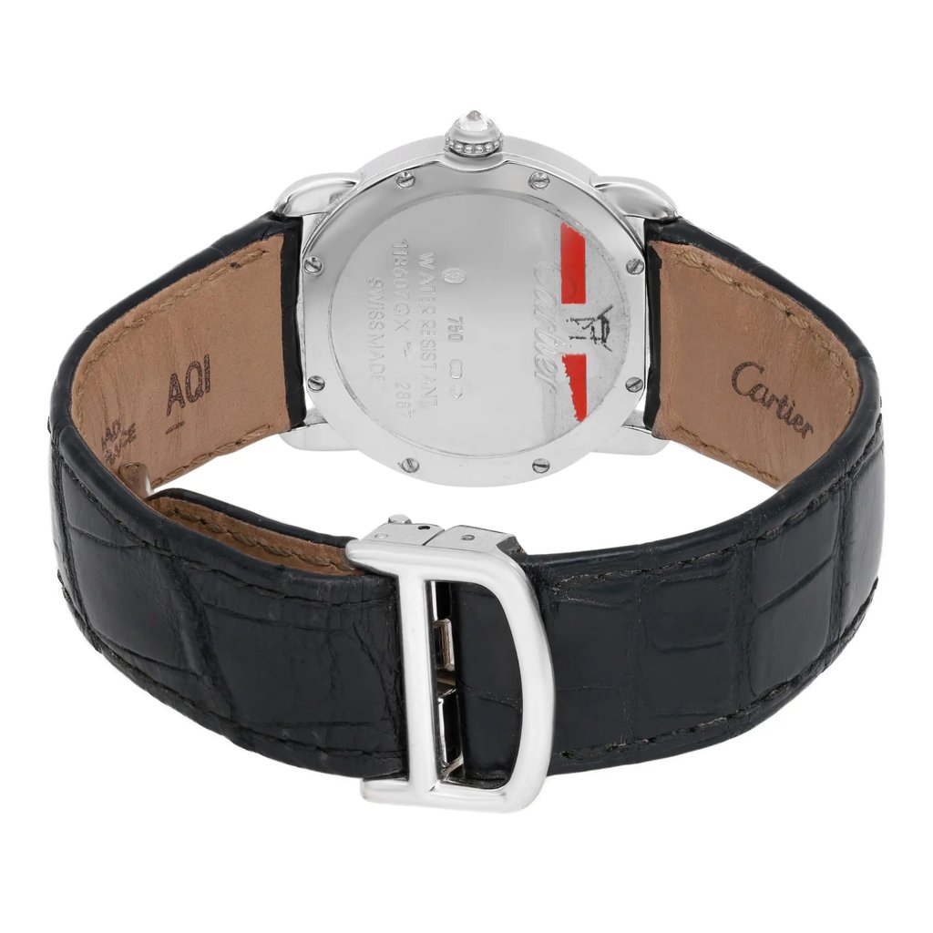 An image of a pre-owned wristwatch viewed from the back, showcasing the closed clasp. The watch features a black leather strap with visible stitching and a polished metal buckle. The case back displays engraved details, with red accents near the top. The angle is slightly elevated, providing a clear view of the strap's interior and the back of the watch, taken at a close distance to highlight the features.